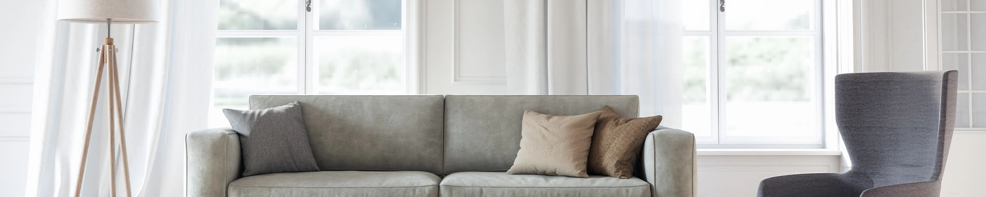 grey living room furniture in room with large window