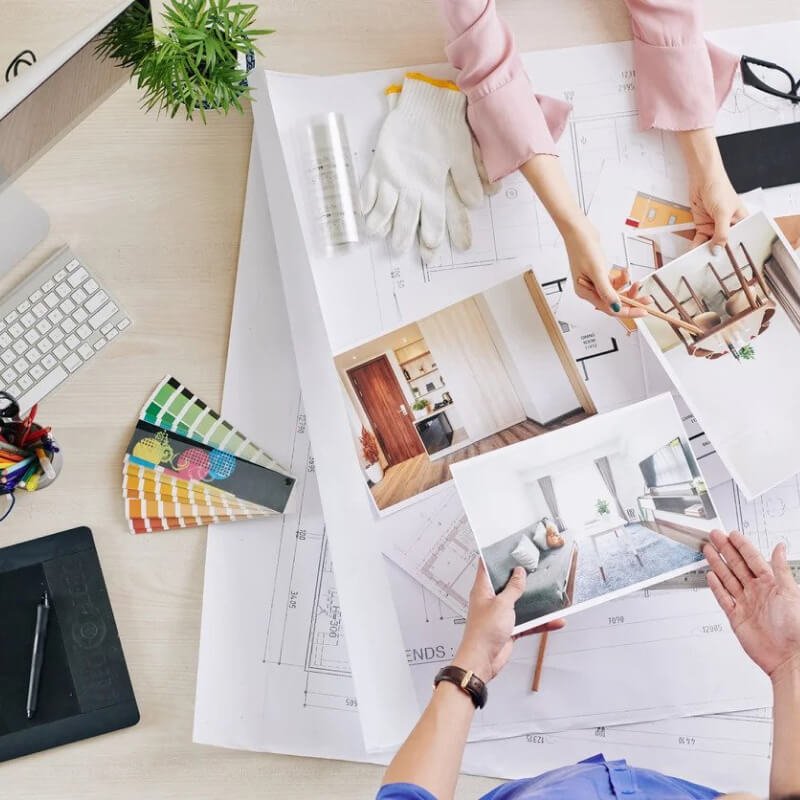 interior design professionals passing plans and photos to each other